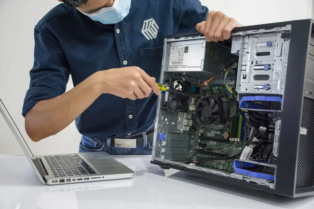 A technician repairs a desktop tower at the workshop